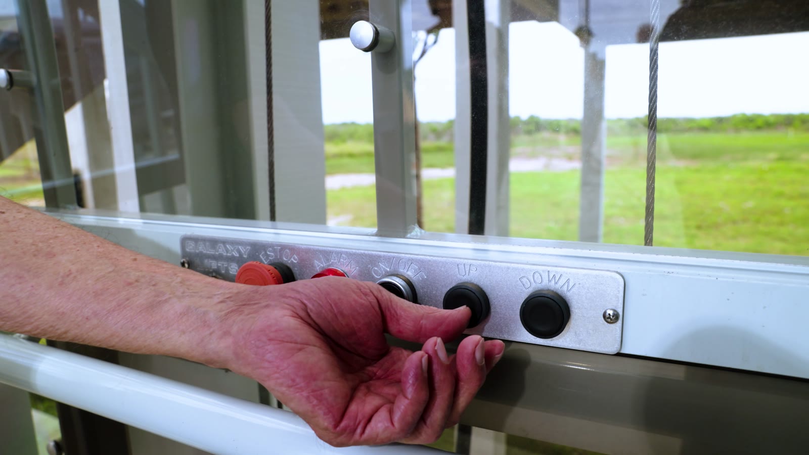 A hand operating the controls inside the Traveler lift